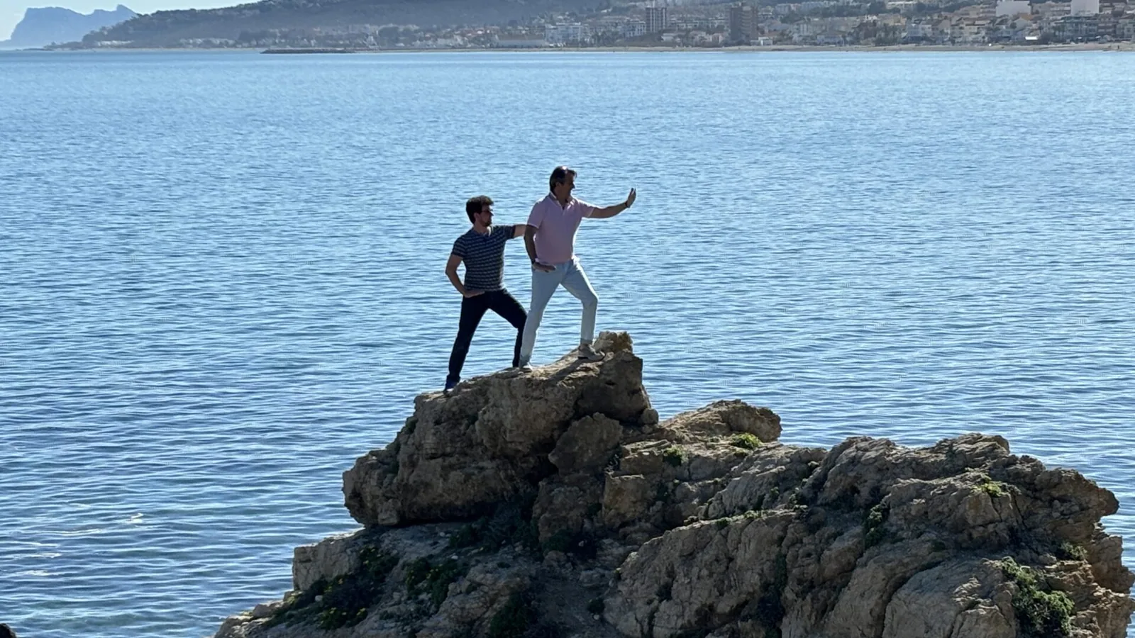 Zwei Menschen auf einem Felsen über dem Meer Zwei Menschen auf einem Felsen über dem Meer